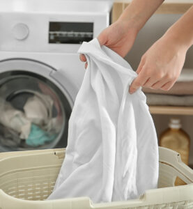 Hands pulling laundry out of a basket