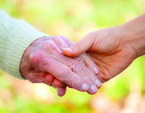 nurse and resident holding hands