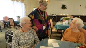Susan Batista discussing upcoming events and plans for activities with residents Betty Wise and Fay Dunkle