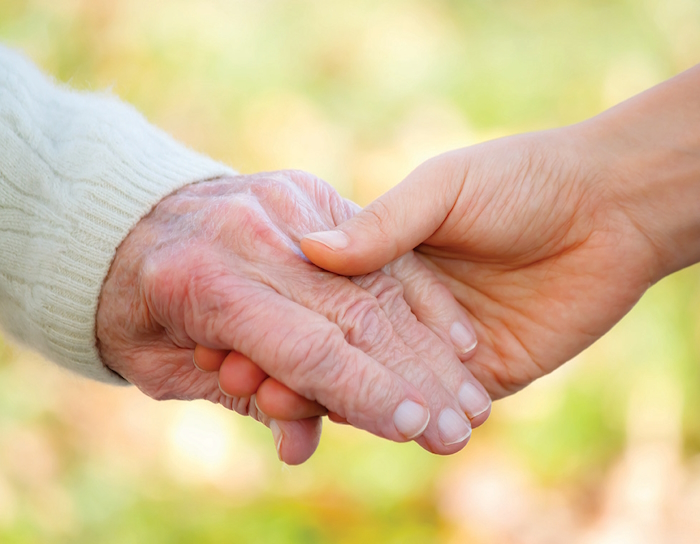 a younger and older person holding hands