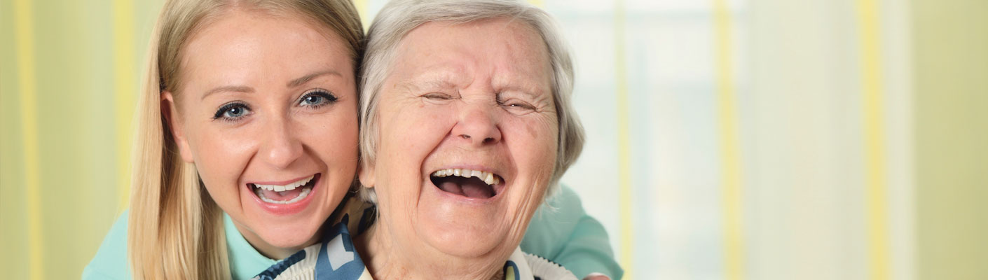 a young adult and elderly woman smiling together