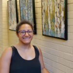 'artist nicole simmons next to her artwork'