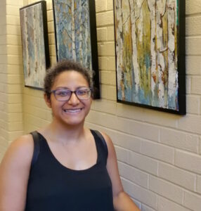 artist nicole simmons next to her artwork