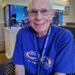 'david sherman smiling next to an aquarium inside homeland'