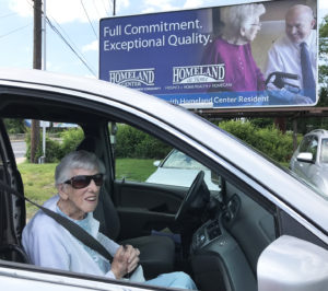 Sara Slothower in a car next to a Homeland billboard