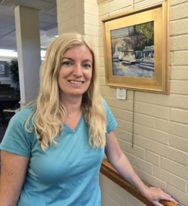 Artist Kelly Charlesworth next to one of her pieces